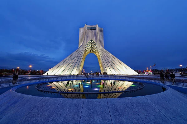 Azadi Tower (Freedom Monument) and cultural complex reflecting in a pond at sunset