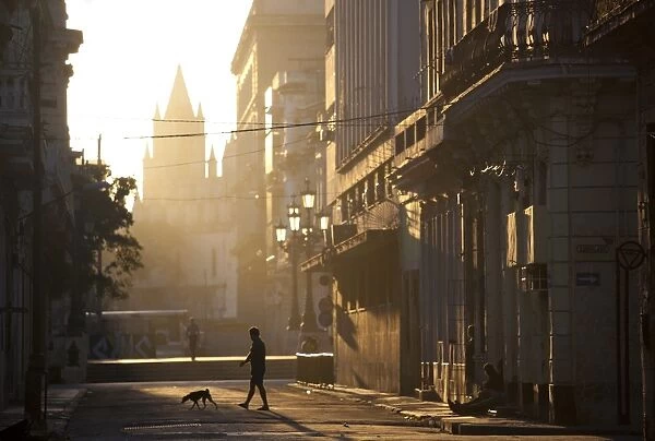 Backlit street at dawn with people in semi-silhouette, off Prado, Havana Centro, Havana, Cuba, West Indies, Central America