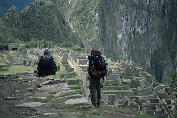 Backpackers look at the Inca ruins at Machu Picchu