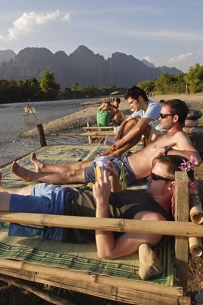 Backpackers relax by the Nam Song river in Vang Vieng