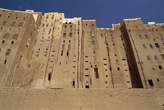 Framed Print : Backs of tall mud brick houses showing holes in the wall for toilets