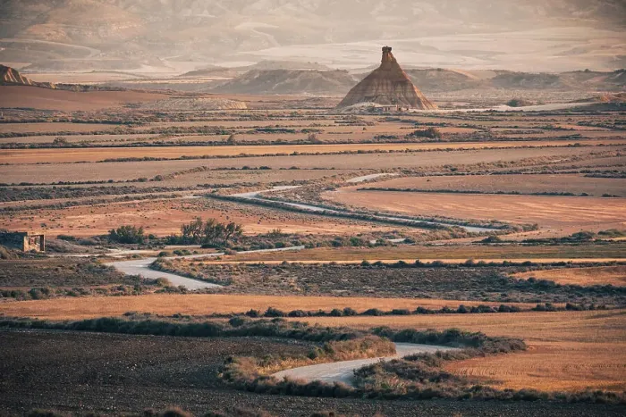 Framed Print : The badlands of Bardenas Reales at sunrise with a winding road leading towards the Castildetierra rock formation, Navarre, Spain, Europe Framed Print : The badlands of Bardenas Reales at sunrise with a winding road leading towards the Castildetierra rock formation, Navarre, Spain, Europe