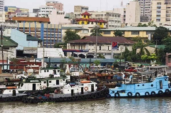 Barges on River Pasig with city buildings behind
