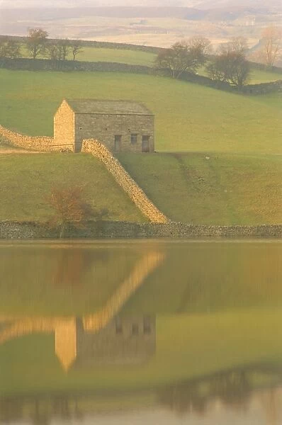 Barn and wall reflected in water at dusk, near Muker, Yorkshire Dales National Park