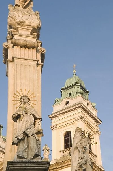 Baroque Church of the Assumption of the Virgin Mary and Baroque plague column at sunset