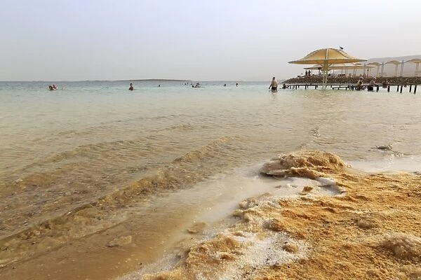 Bathers in the Dead Sea, with salty shoreline, Ein Bokek (En Boqeq) beach, Israel