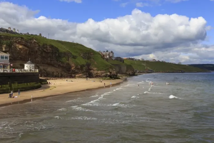 Framed Print : Bathers on West Cliff Beach, backed by grassy cliffs in summer, Whitby, North Yorkshire Framed Print : Bathers on West Cliff Beach, backed by grassy cliffs in summer, Whitby, North Yorkshire
