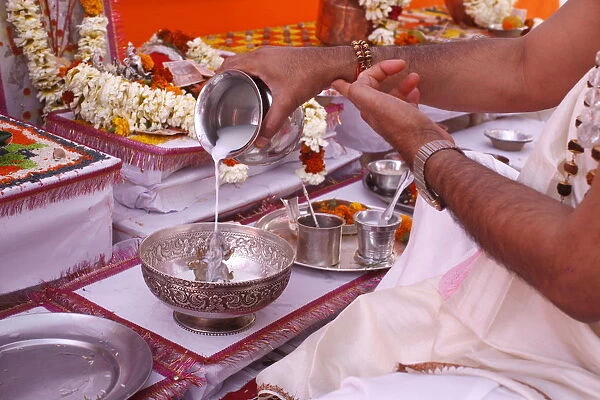 Bathing a statue of the goddess Durga with milk during Puja in a Hindu temple, Haridwar