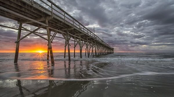 Beach, ocean, waves and pier at sunrise, Sunset Beach, North Carolina, United States of America