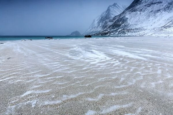 Beach partially snowy surrounded by mountains, Haukland, Lofoten Islands, Northern Norway