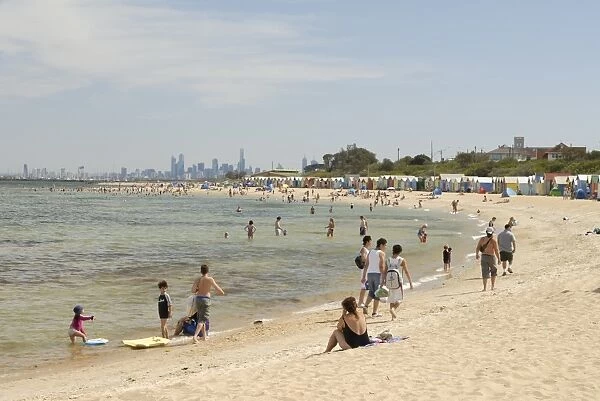 Beach scene with beach huts at Brighton Beach, Brighton, and in background skyscrapers of City of Melbourne, Victoria