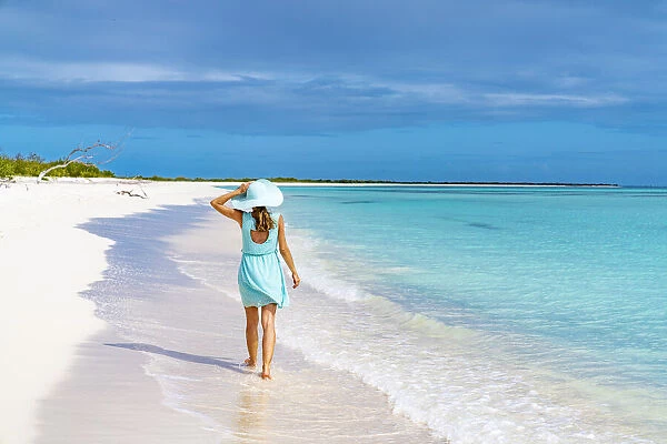 Beautiful woman walking on idyllic beach washed by Caribbean Sea, Barbuda, Antigua and Barbuda, West Indies, Caribbean, Central America