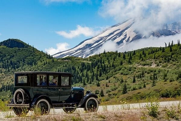 Beautifully restored Vintage American car passing Mount St. Helens, part of the Cascade Range