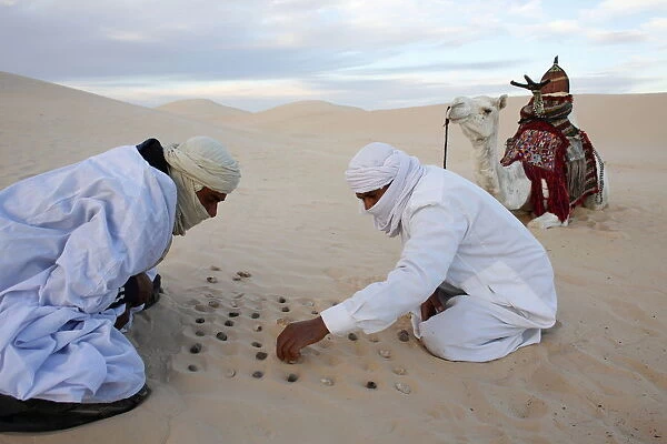 Bedouins playing with stones in the sand, Douz, Kebili, Tunisia, North Africa, Africa