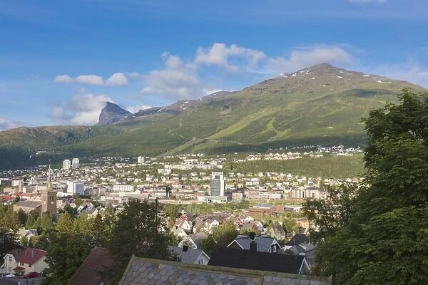 Bell tower and houses of the city surrounded by rocky peaks and green hills, Narvik