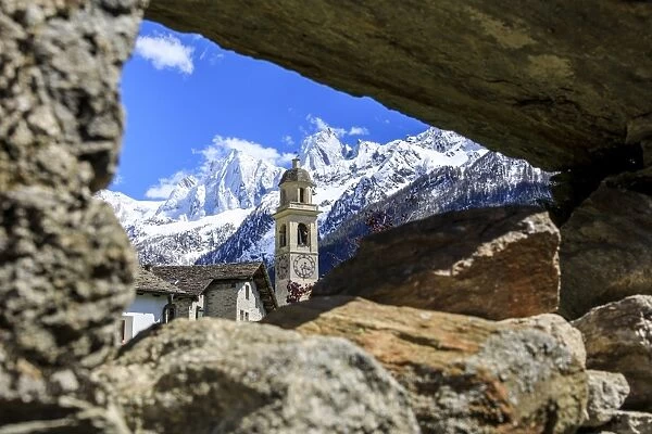 Bell tower and snowy peaks seen from stone arch, Soglio, Maloja, Bregaglia Valley