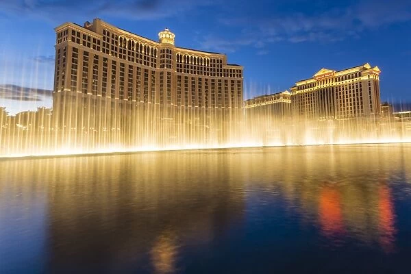 Bellagio and Caesars Palace reflections at dusk with fountains, The Strip, Las Vegas, Nevada, United States of America, North America