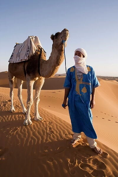 Berber man standing with his camel