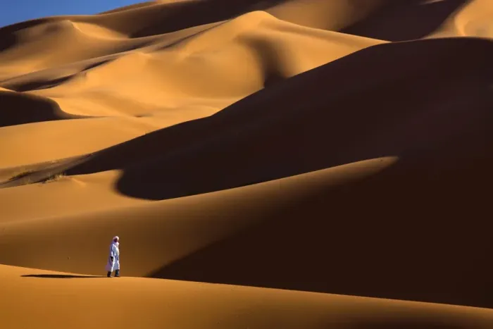 Framed Print : Berber man walking among the orange sand dunes of the Erg Chebbi sand sea, Sahara Desert near Merzouga, Morocco, North Africa, Africa Framed Print : Berber man walking among the orange sand dunes of the Erg Chebbi sand sea, Sahara Desert near Merzouga, Morocco, North Africa, Africa
