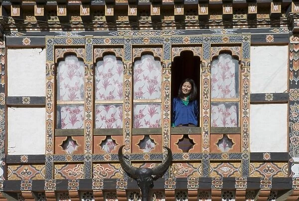 Bhutanese woman at window of typical Bhutanese house, Jankar, Bumthang Valley