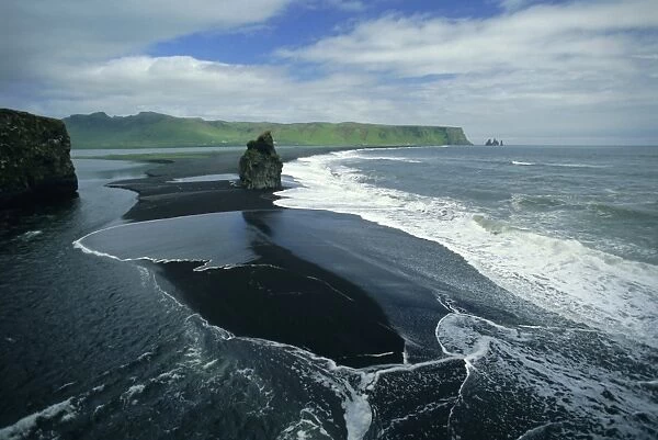 Black volcanic sand and sea stack at south coast bird sanctuary