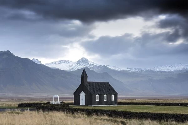 Black wooden church against mountains, Budir, Snaefellsnes Peninsula, Iceland, Polar
