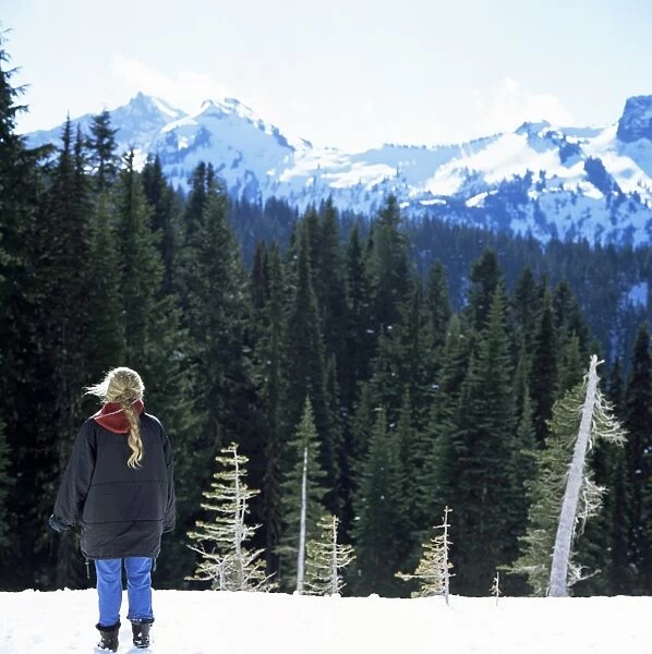 Blonde girl looks at snow covered peaks from the Paradise Lodge
