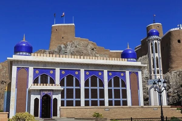 Blue domed mosque with minaret and Al-Mirani Fort, Old Muscat, Oman, Middle East