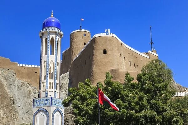 Blue domed mosque minaret, Oman, Middle Easti National Flag and Al-Mirani Fort, Old Muscat