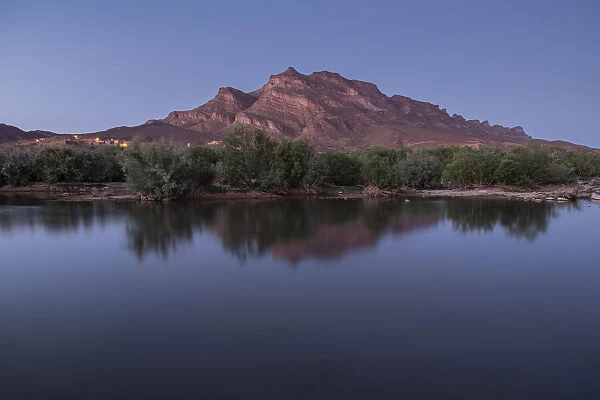 Blue hour in an oasis in the Draa Valley with a calm pond