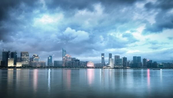 Blue hour shot of Jianggang district lights slowly coming to life under a dramatic sky