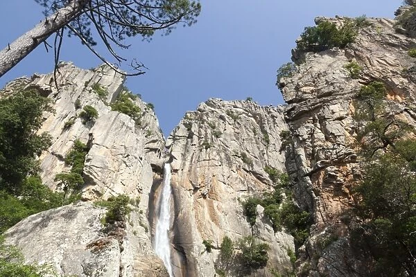 Blue sky frames The Piscia di Gallo waterfall surrounded by granite rocks, Zonza