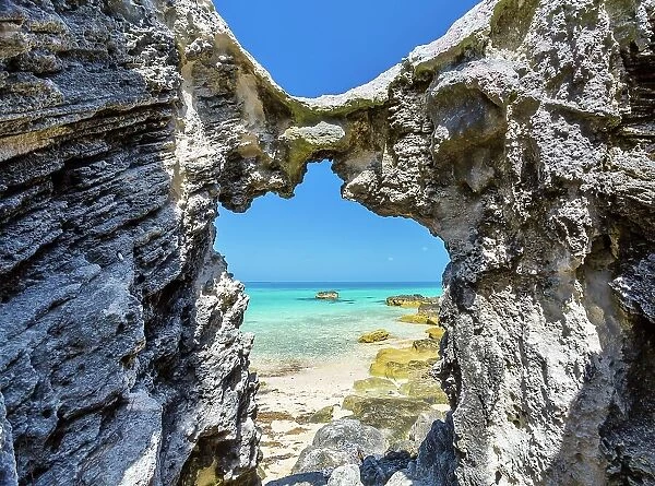 Blue and turquoise Sargasso Sea, glimpsed through an arch in the island's distinctive rocks, Bermuda, Atlantic, North America