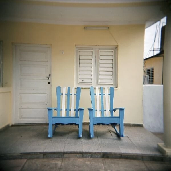 Blue and white chairs against a yellow wall, Vinales, Cuba, West Indies, Central America