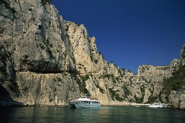 Boat dwarfed by cliffs of the Calanque d En-Vau, near Cassis, Bouches-du-Rhone