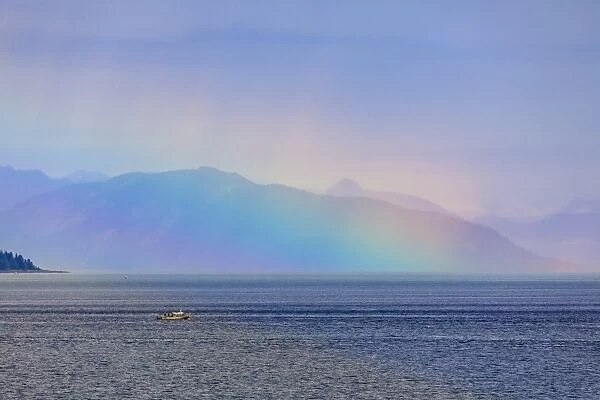 Boat, huge rainbow colours light up mist over the Fairweather Range, Icy Strait, near Glacier Bay