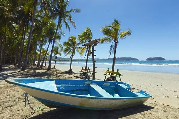 Boat on the palm-fringed beach at this laid-back village & resort, Samara, Guanacaste Province, Nicoya Peninsula, Costa Rica, Central America