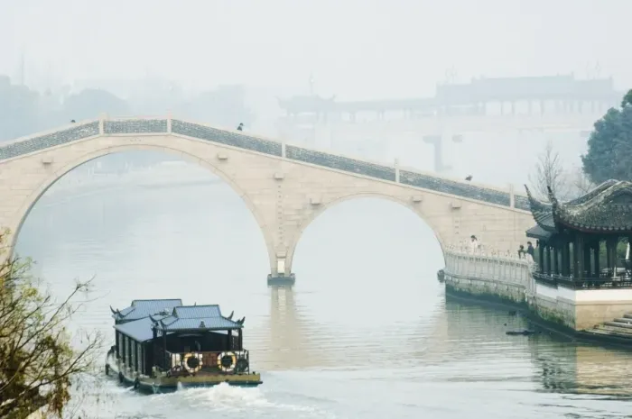 Framed Print : A boat passing through a stone arched bridge on Waicheng River with Wumen bridge behind Framed Print : A boat passing through a stone arched bridge on Waicheng River with Wumen bridge behind
