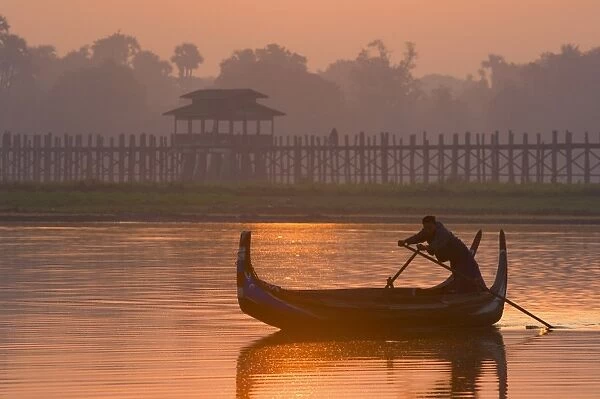 Boat on Thaungthaman Lake, and U Beins Bridge, at 1. 2 km long the worlds longest teak bridge, Amarapura, Myanmar