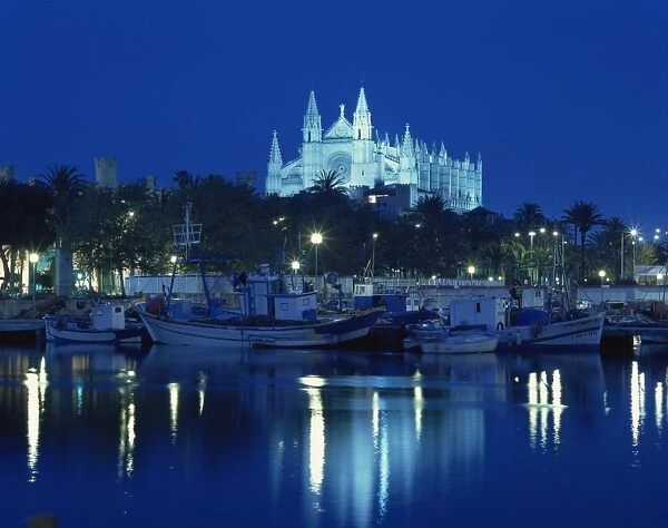 Boats in the bay below the illuminated cathedral at Palma on Majorca, Balearic Islands
