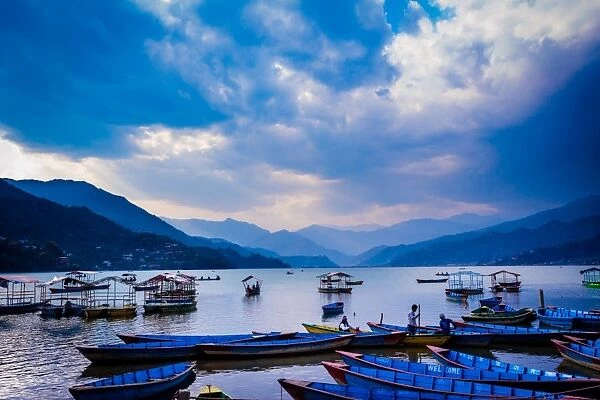 Boats docked on a lake at sunset in Pokhara, Nepal, Asia