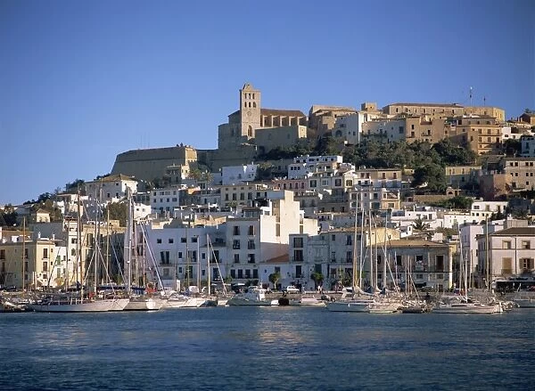 Boats in the harbour and the houses and church of Ibiza Town behind