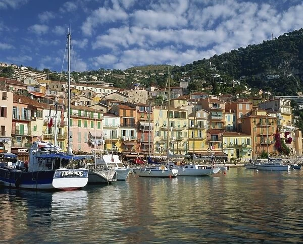 Boats in the harbour and painted houses on the waterfront in the town of Villefranche