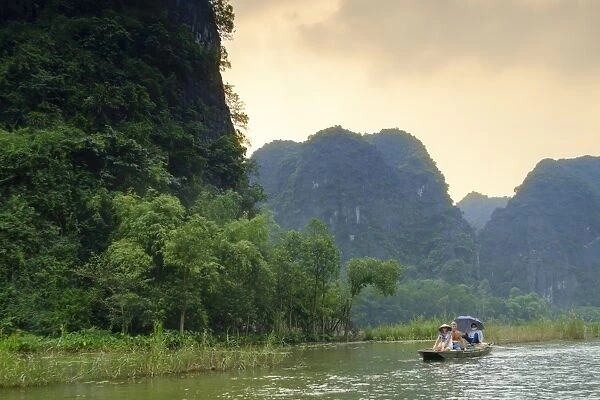 Boats in the karst landscapes of Tam Coc and Trang An in the Red River area, UNESCO