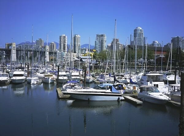Boats moored in False Creek by Granville Island with the Burrard Bridge