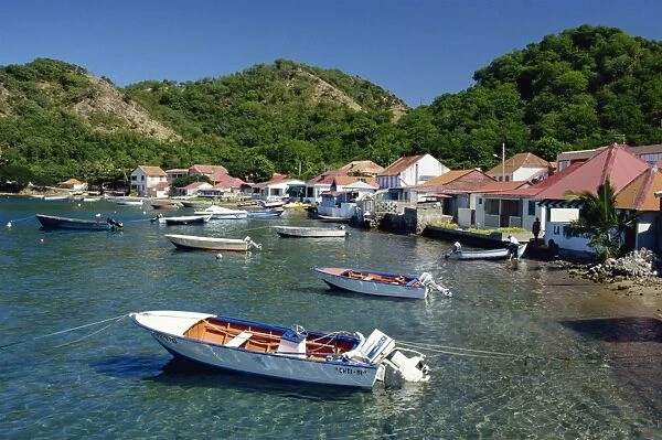 Boats moored behind houses built on the beach of a bay