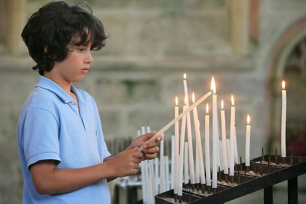 Boy lighting a church candle