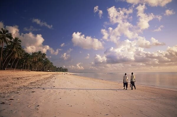 Two boys walking to school along the beach at Jambiani, Zanzibar, Tanzania