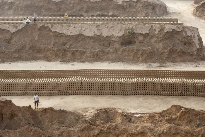 Framed Print : Brick workers amongst hand made bricks laid out on the ground to dry before baking Framed Print : Brick workers amongst hand made bricks laid out on the ground to dry before baking