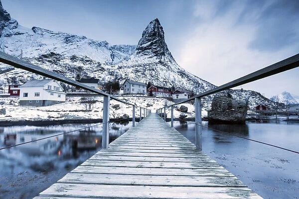 A bridge over the cold sea connects a typical fishing village. Reine, Lofoten Islands